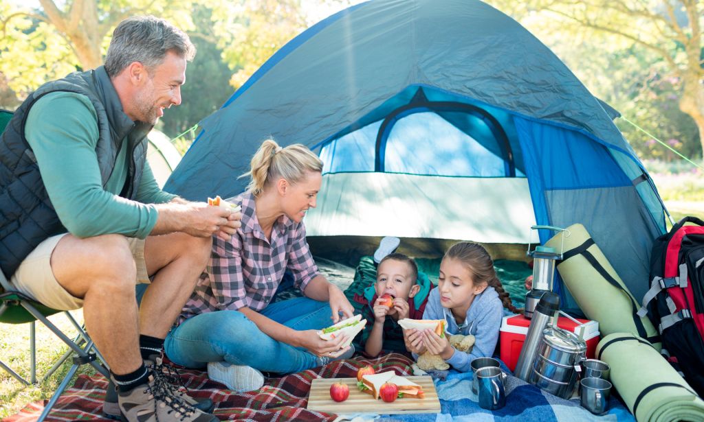 A family sat by their tent on a camping trip
